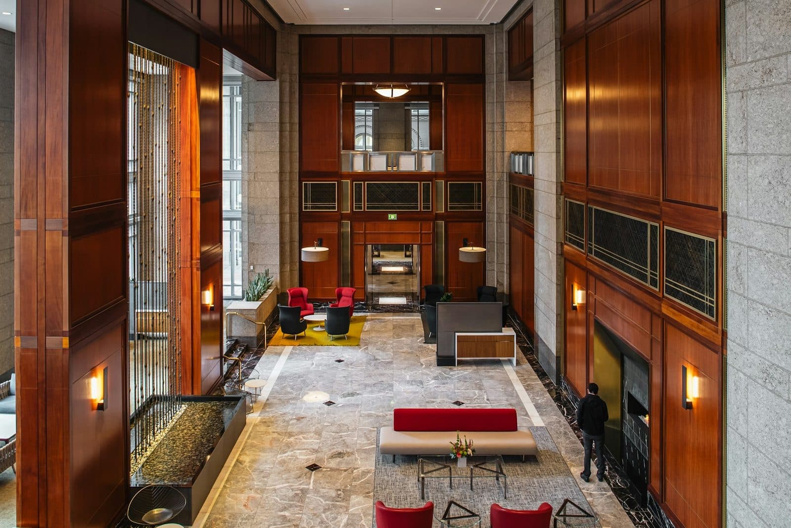 Office building lobby with polished marble floor, granite stone walls, and wood paneling