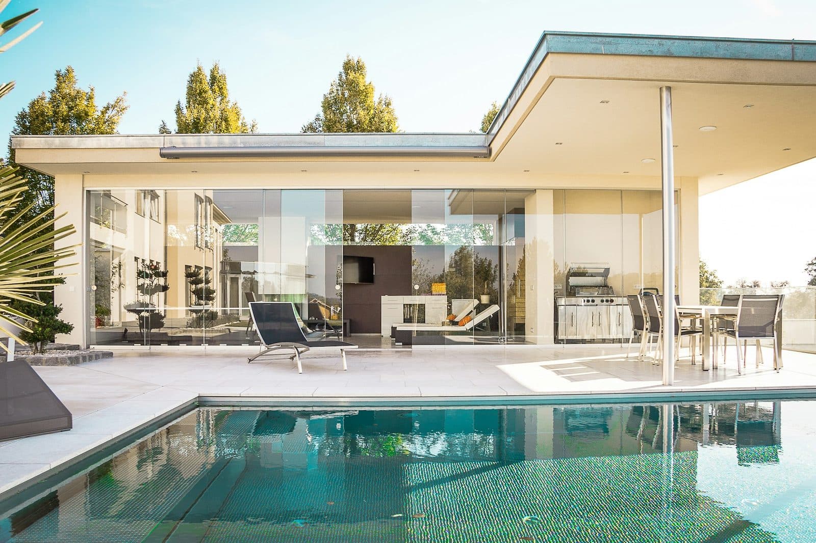 Covered patio with large-format outdoor porcelain pavers leading to a pool