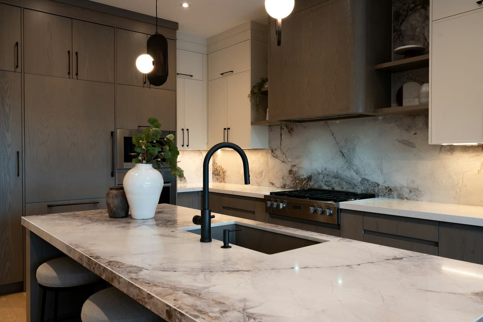 Luxury kitchen with white marble island, waterfall edge, and matching marble backsplash